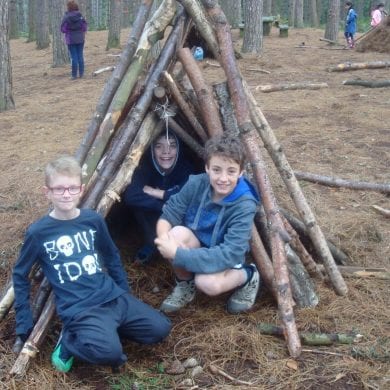 Siblings building tree den in forest