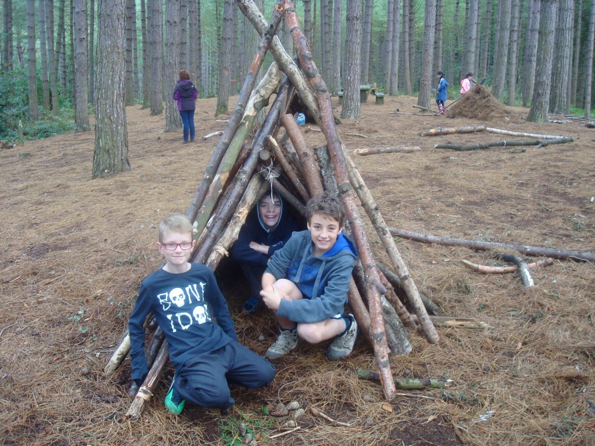 Siblings building tree den in forest