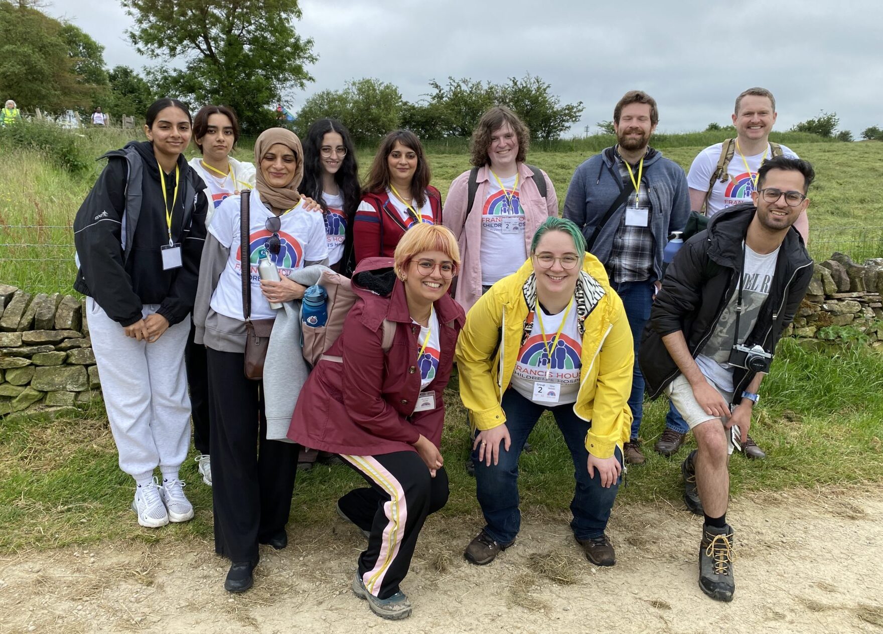 A big group of friends and family smile to camera as they get ready to begin their walk