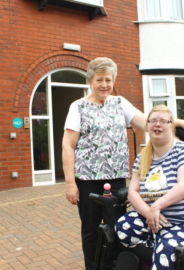 Young person in wheelchair with staff outside 463