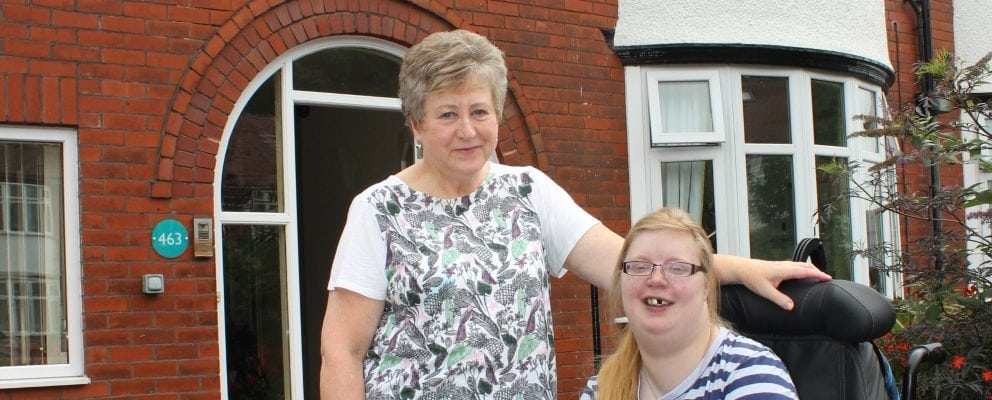 Young person in wheelchair with staff outside 463
