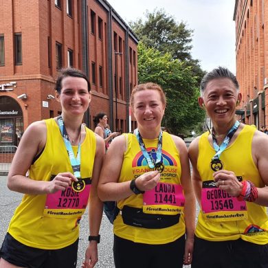 A team of runners hold up their medals after completing the Great Manchester Run
