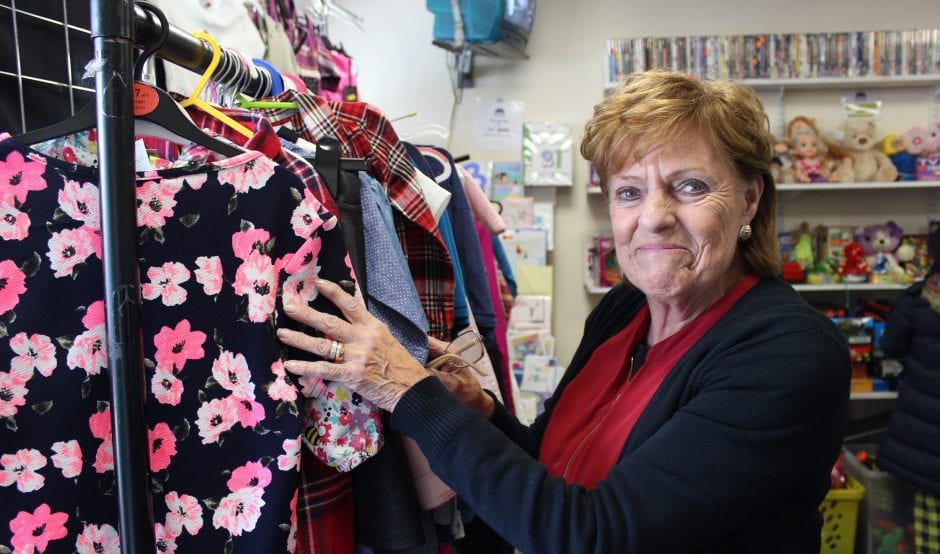 Shop volunteer sorts clothing racks