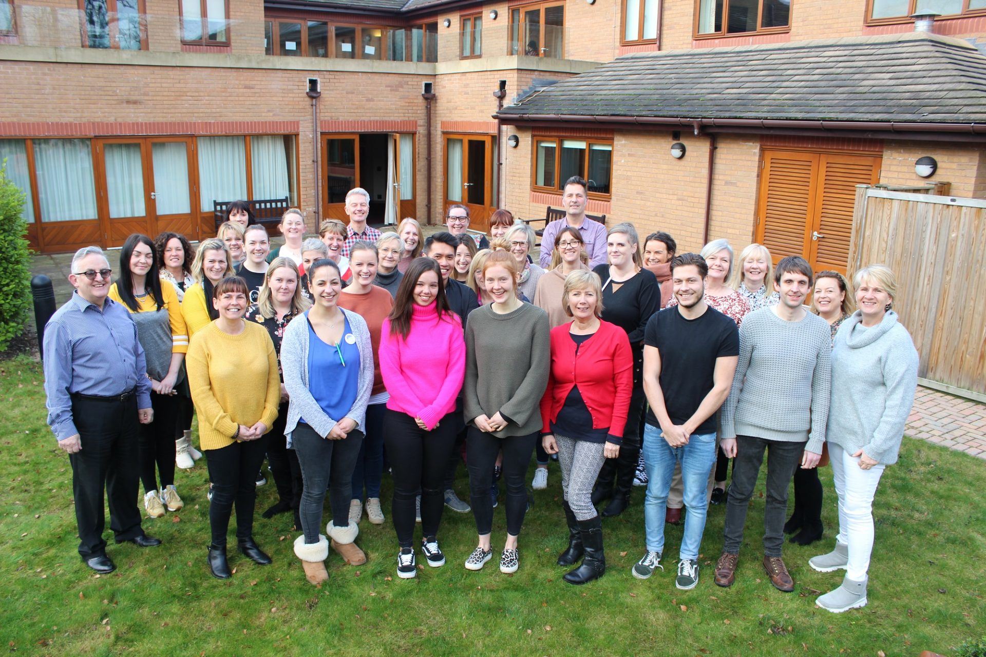 Francis House care team on the lawn outside Francis Lodge