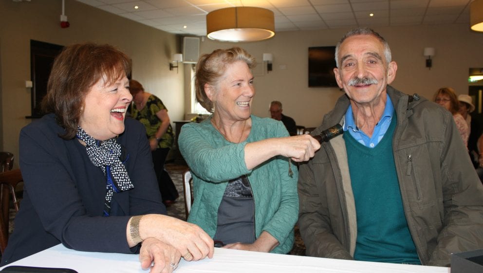 Margie Cooper with Brenda and Alan Lathwood taps husband Alan on the shoulder with tipstaff