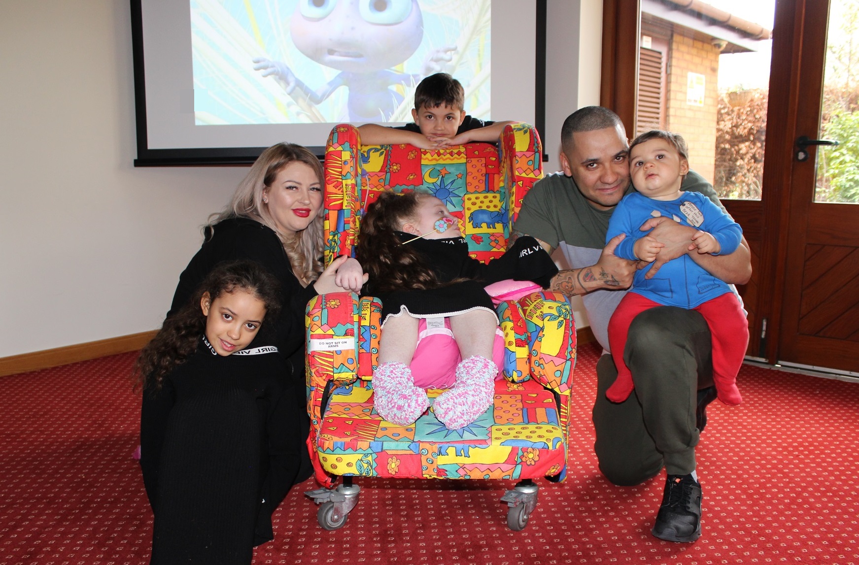 Family in the cinema room at Francis House.