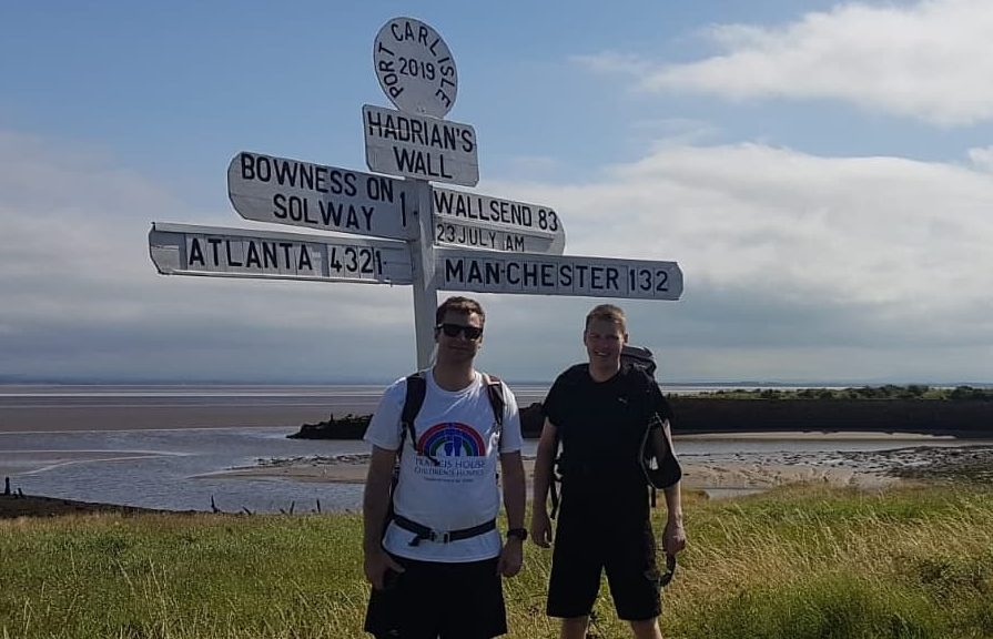 Two men stood at sign post