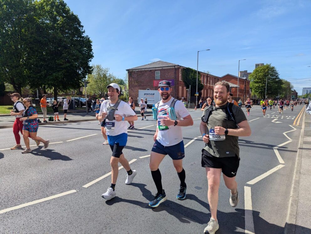 Three runners in the 2025 Manchester Marathon, one in a Francis House t-shirt