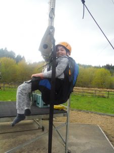 Young person in harness on high swing