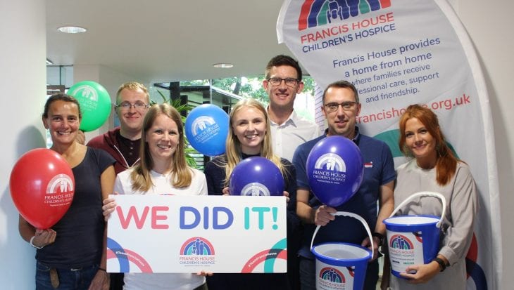 Group of people holding Francis House charity balloons and banners