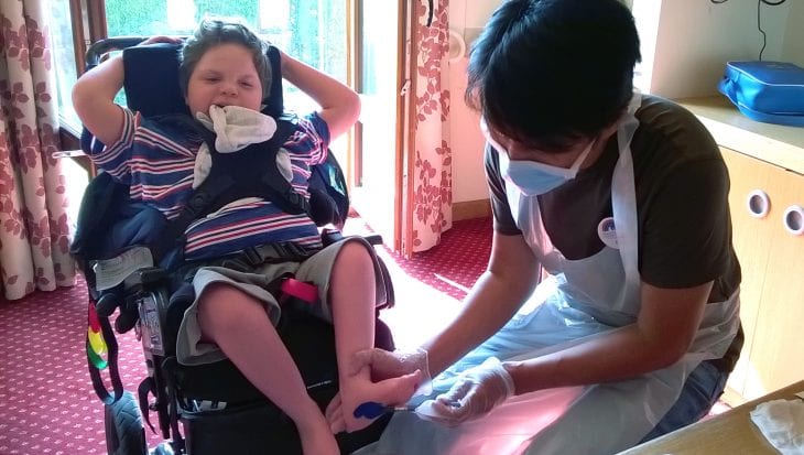 Child smiling having feet painted