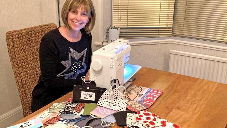 Tracey Sutherland sat at sewing machine making face coverings