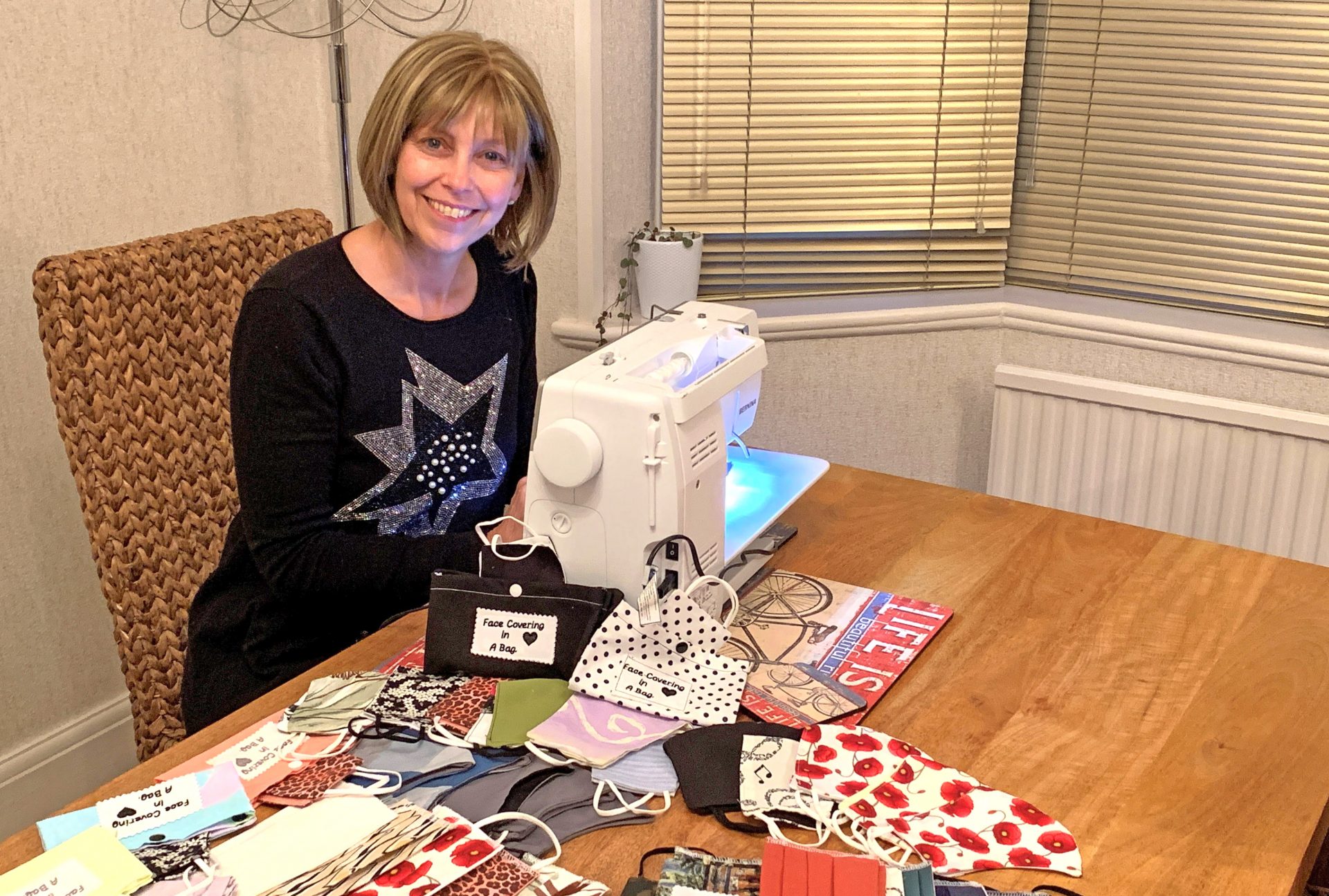 Tracey Sutherland sat at sewing machine making face coverings