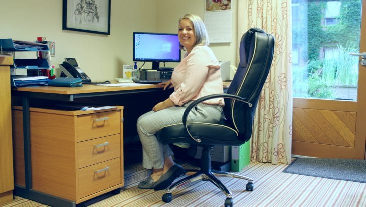 Sharon Doodson seated at desk at Francis House