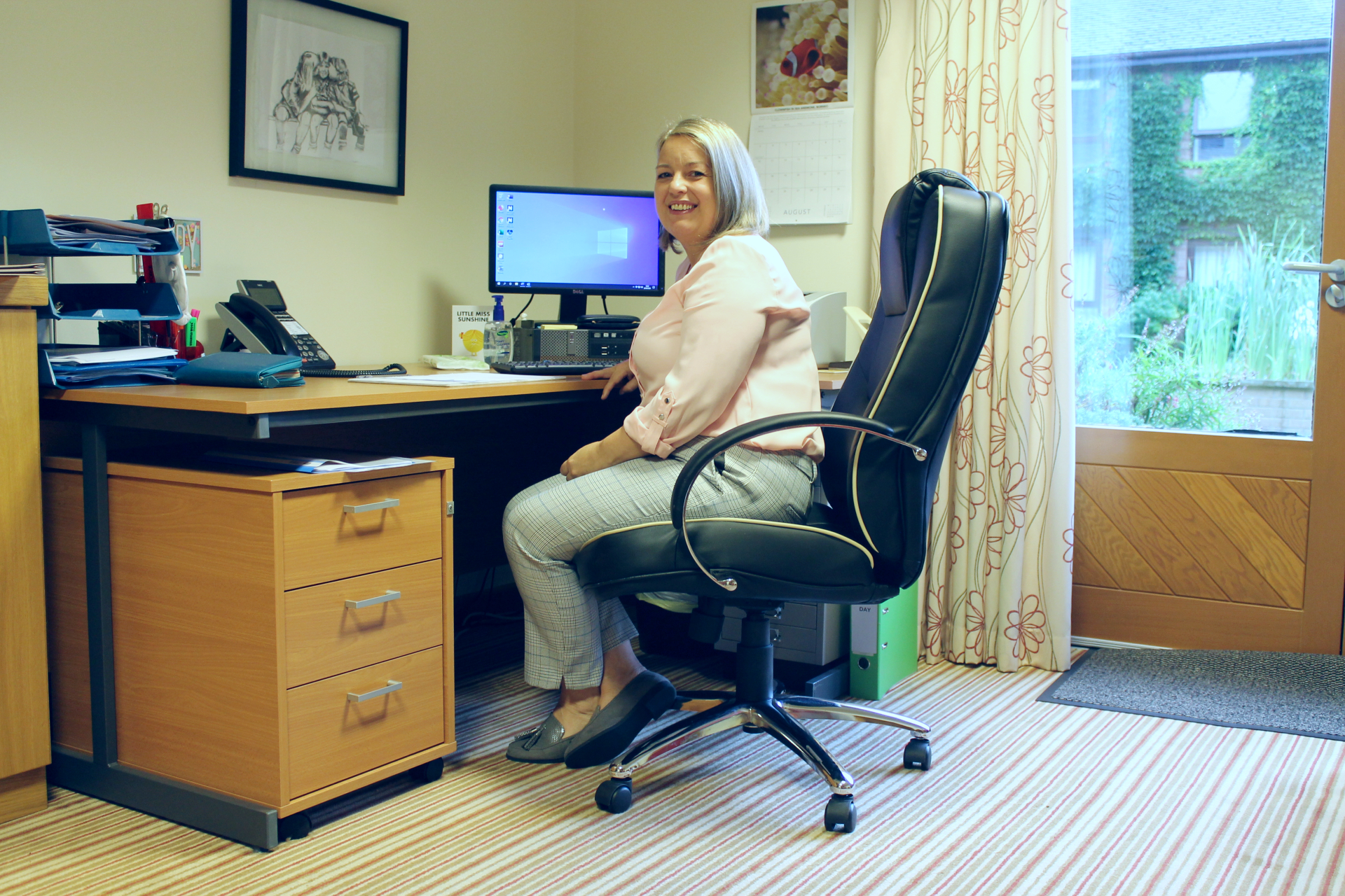 Sharon Doodson seated at desk at Francis House