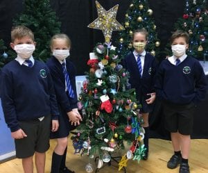 School pupils stood by Christmas tree