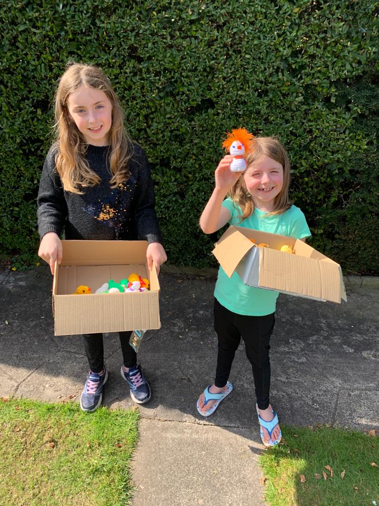 Children holding knitted chicks