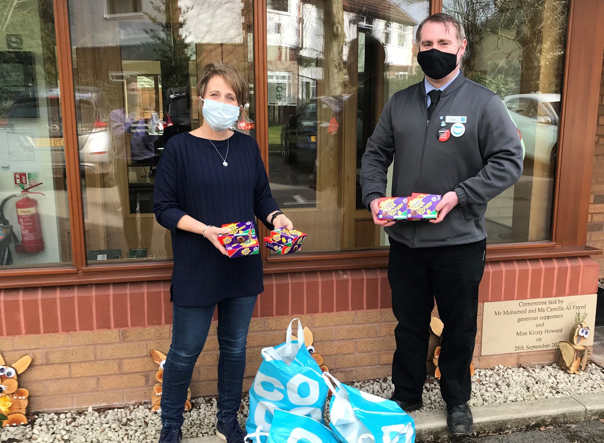 People wearing masks holding creme eggs