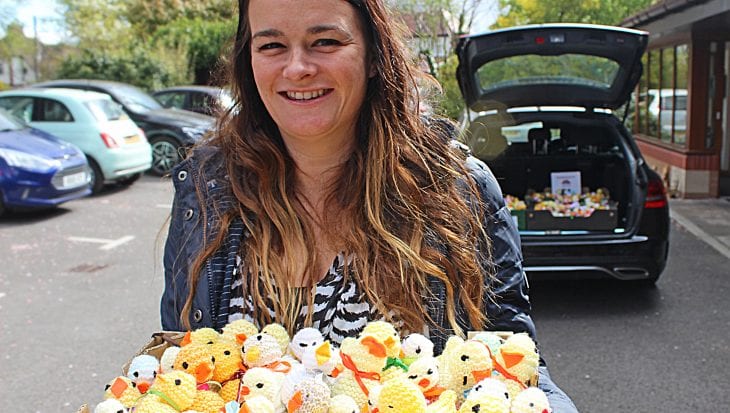 Woman holding box of knitted chicks