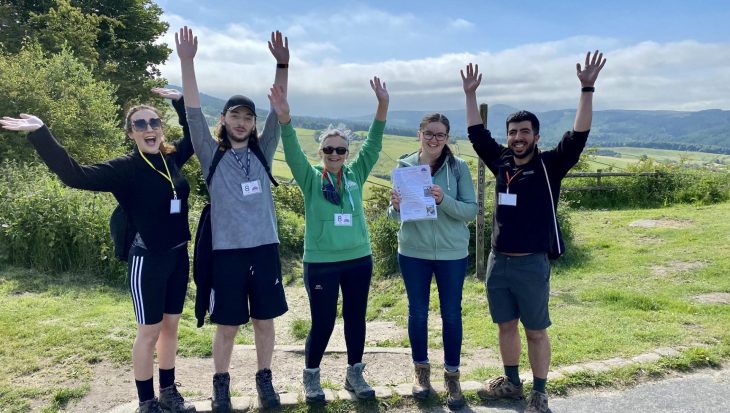 Group of people outside with hands in the air