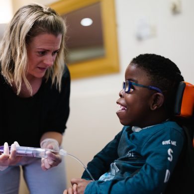 Francis House nurse tube feeding a child