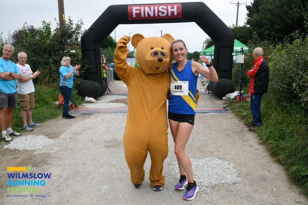 Runner and mascot posing at the finish line