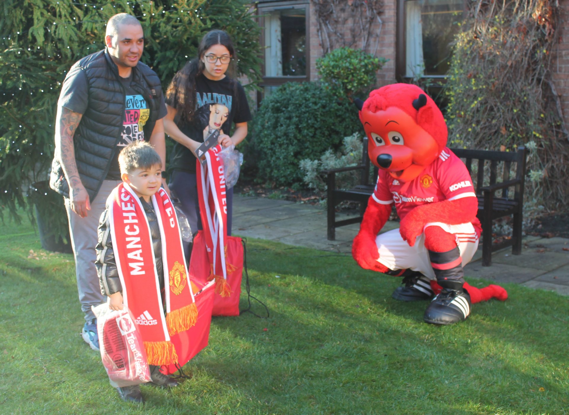 Family with Manchester United gifts and Fred the Red mascot