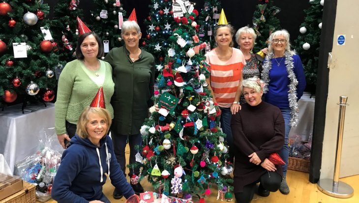 Members of Uplift Cafe and knitting group stood by Christmas tree