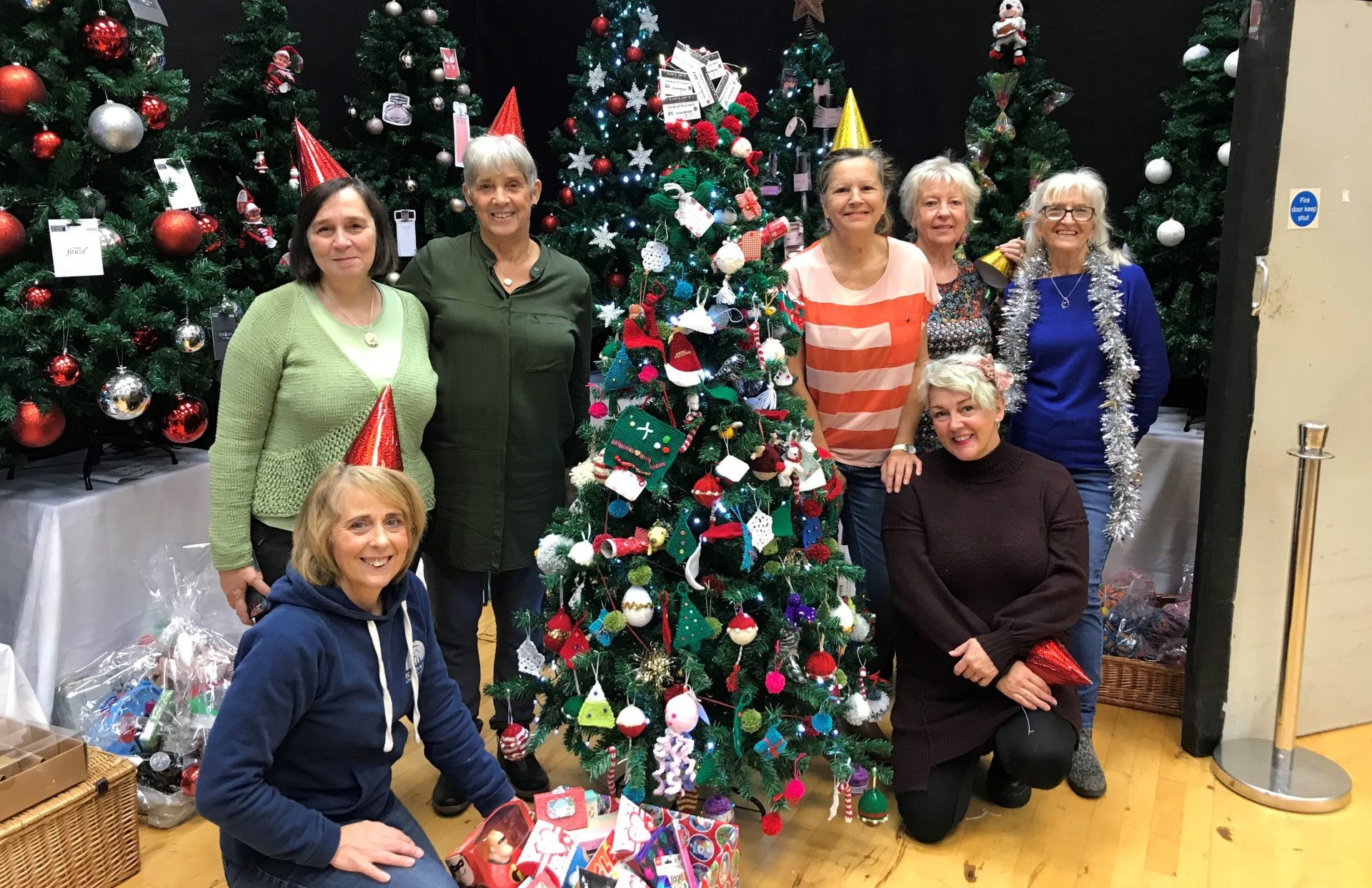 Members of Uplift Cafe and knitting group stood by Christmas tree