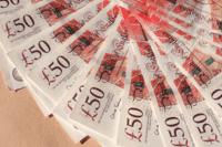 Fifty pound notes fanned out on a table