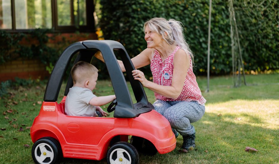 Child sat in toy car with care staff