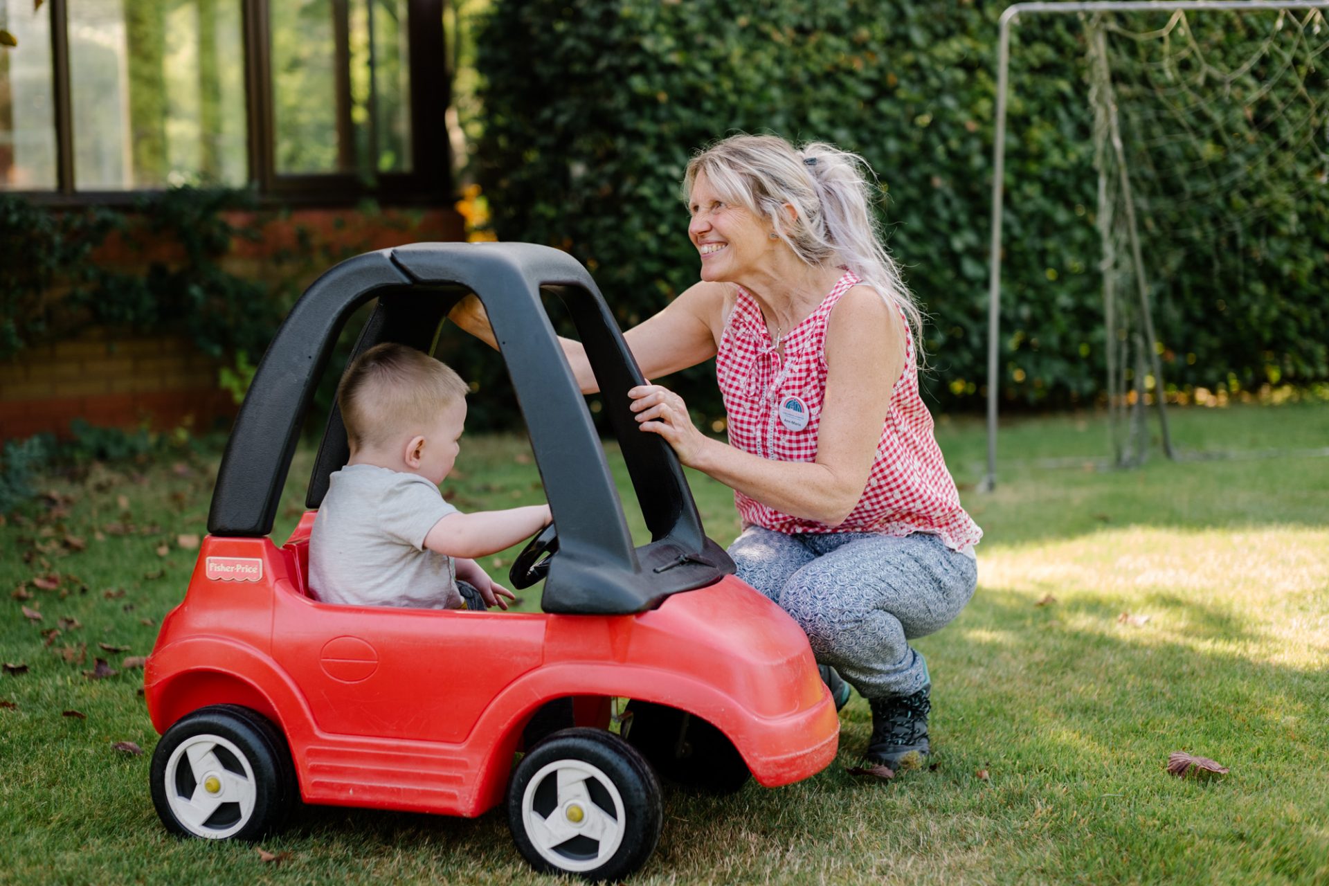 Child sat in toy car with care staff