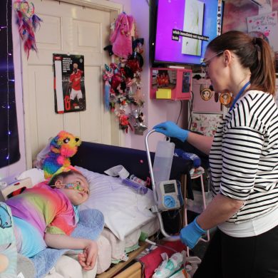 Homecare team nurse Alison giving child water through a tube