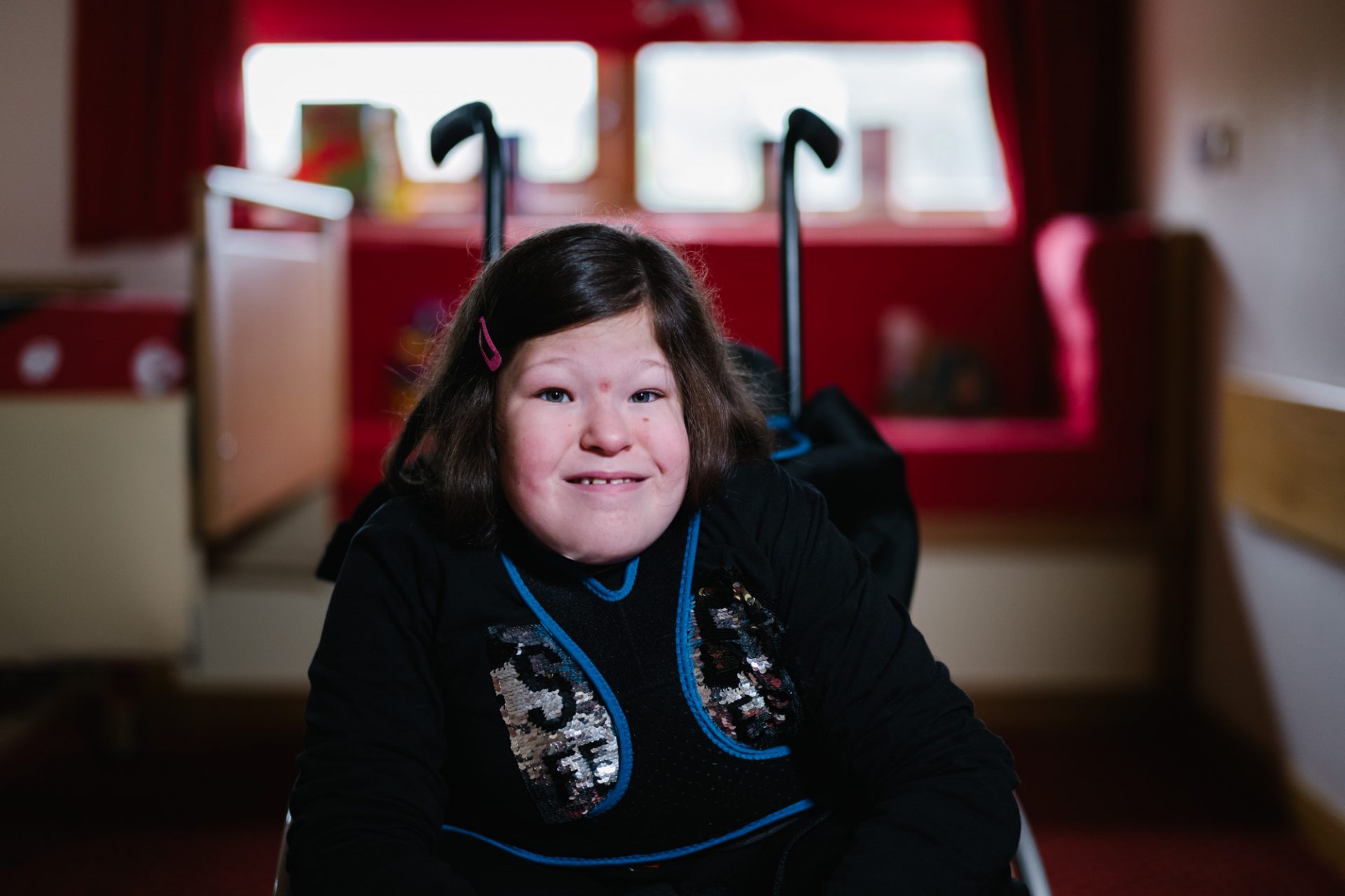 Young smiling girl sat in a wheelchair