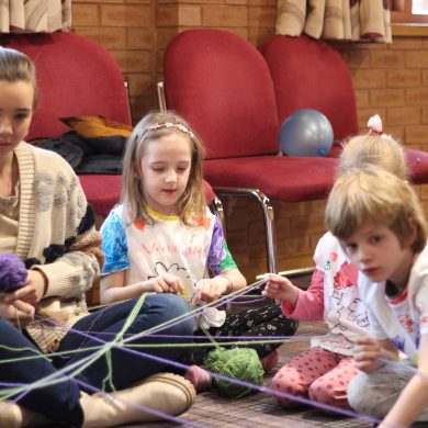 Children playing a game with wool