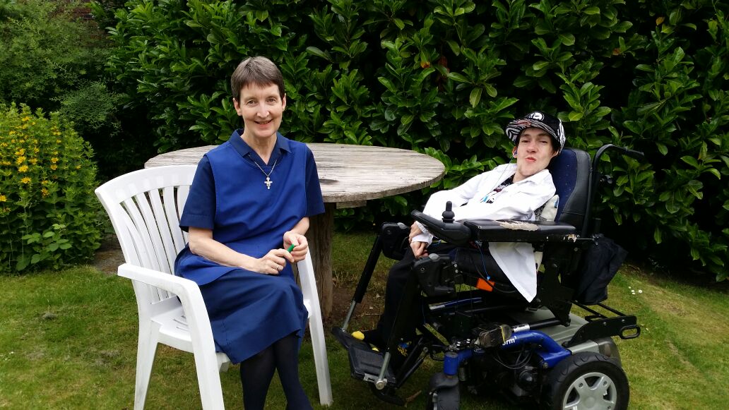 Sister Maureen seated with Kyle in the garden at 463