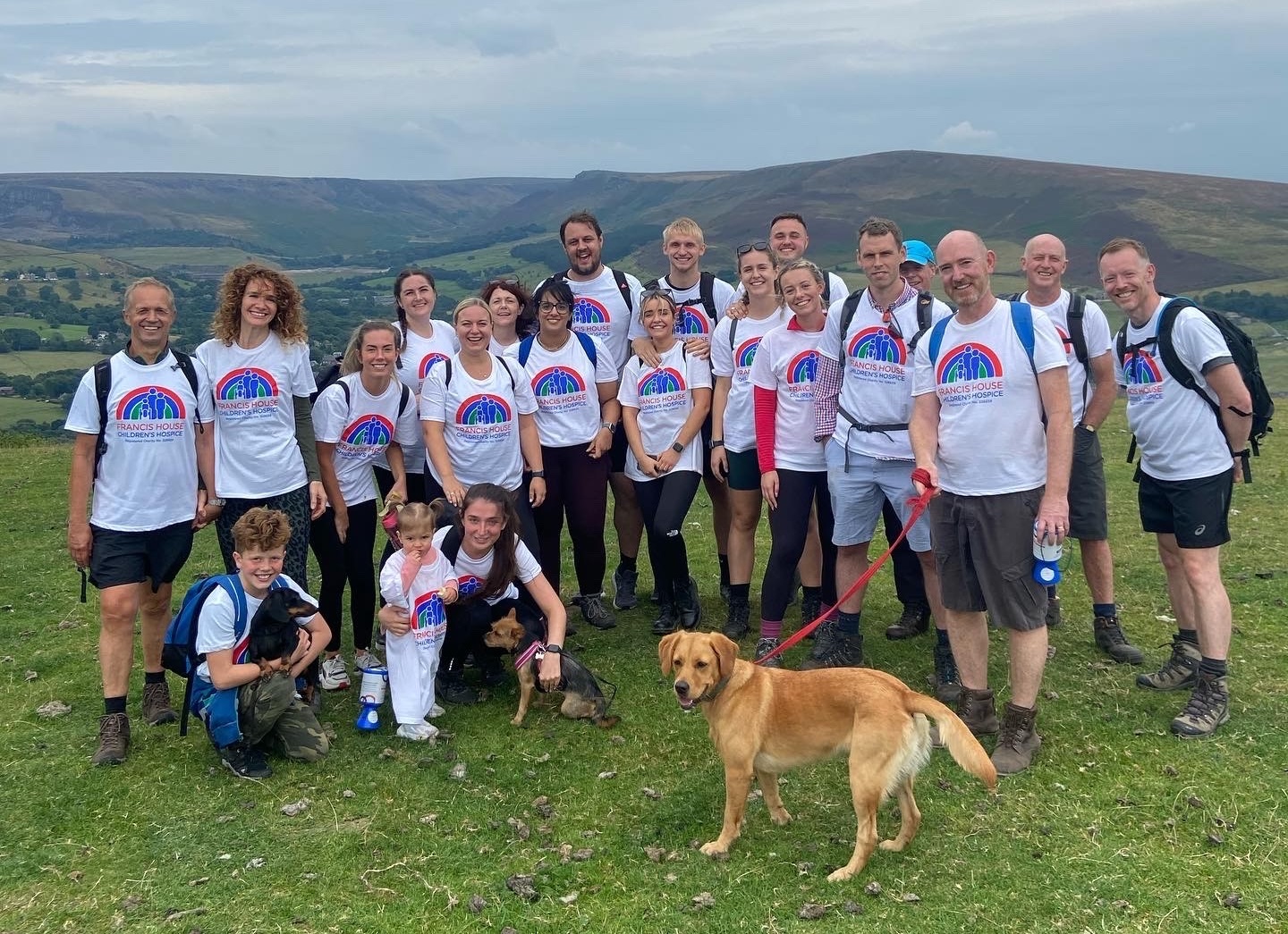 Group of people and dogs on a hill top