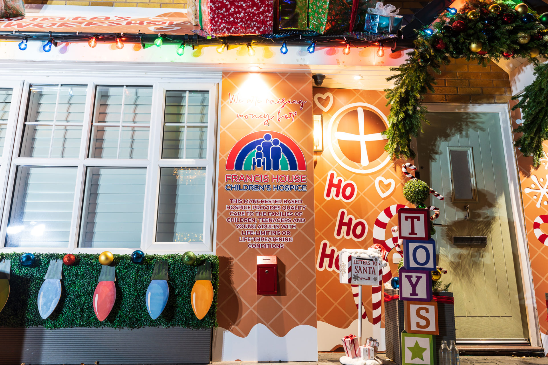 House decorated with lights and Francis House charity box