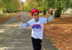 Boy waving arms in the air in park