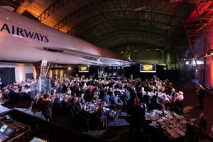 Hundreds of people at an evening reception under the wings of Concorde