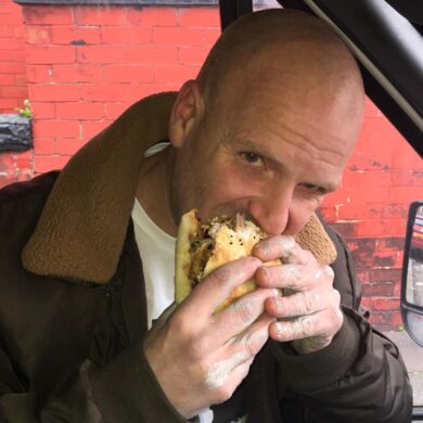 Man eating kebab in a van