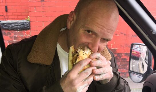 Man eating kebab in a van