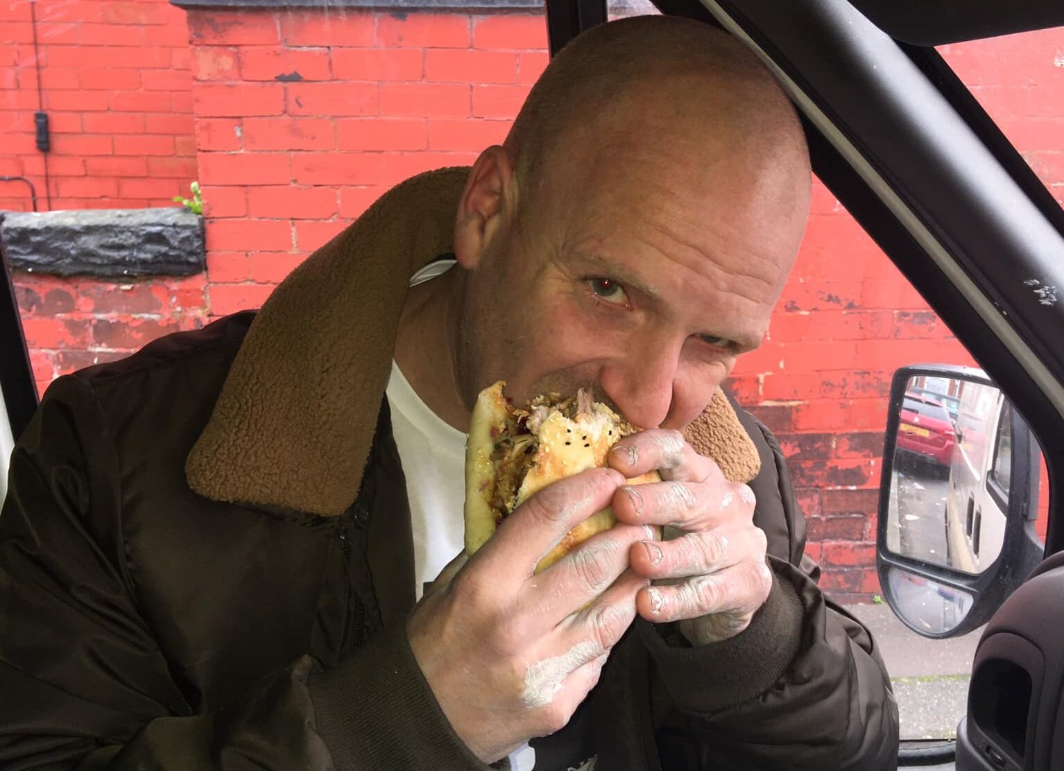 Man eating kebab in a van