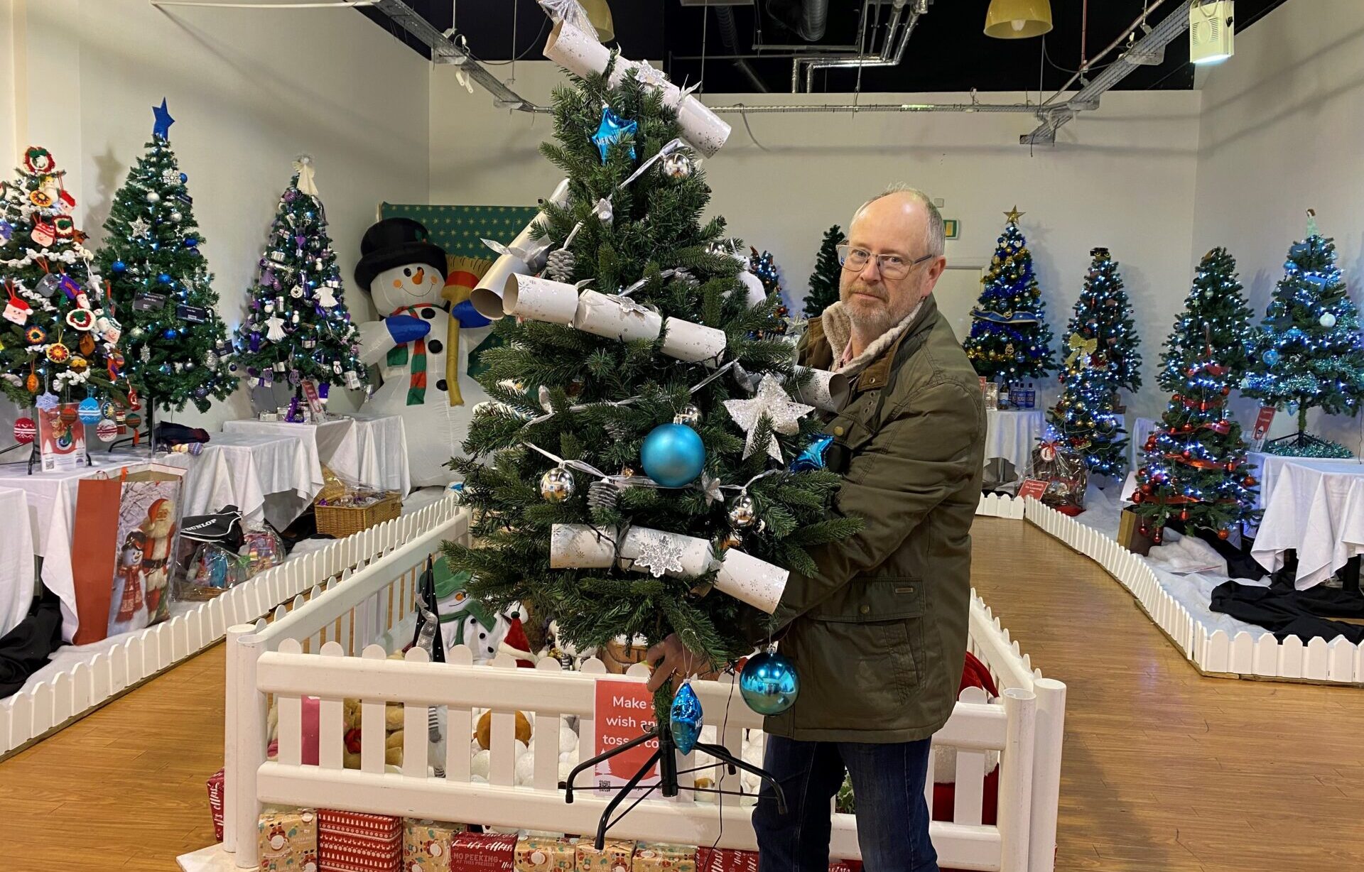 Man holding Christmas tree in a shop