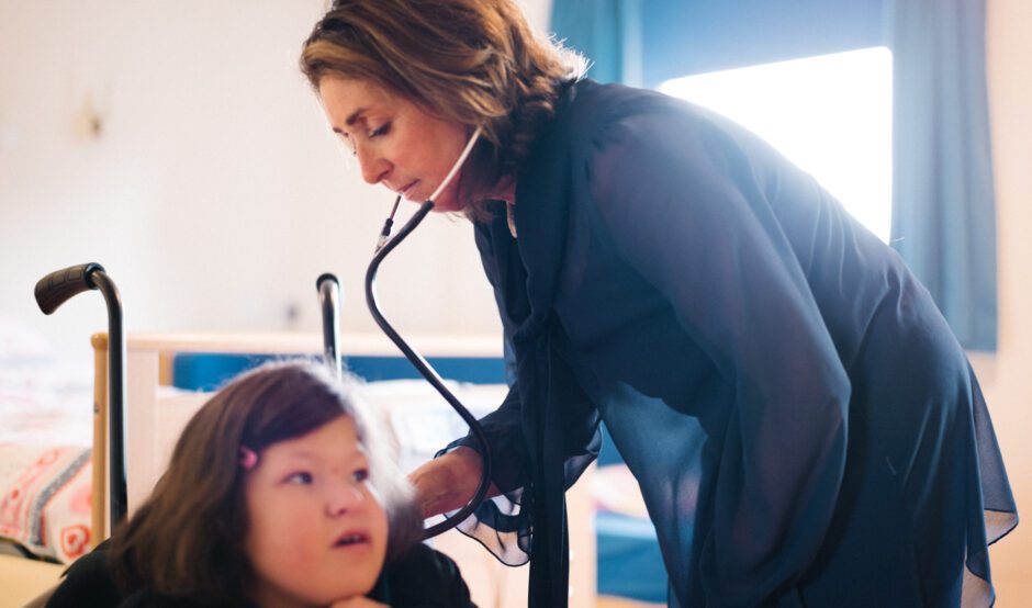 Doctor with stethoscope listening to a child breathing