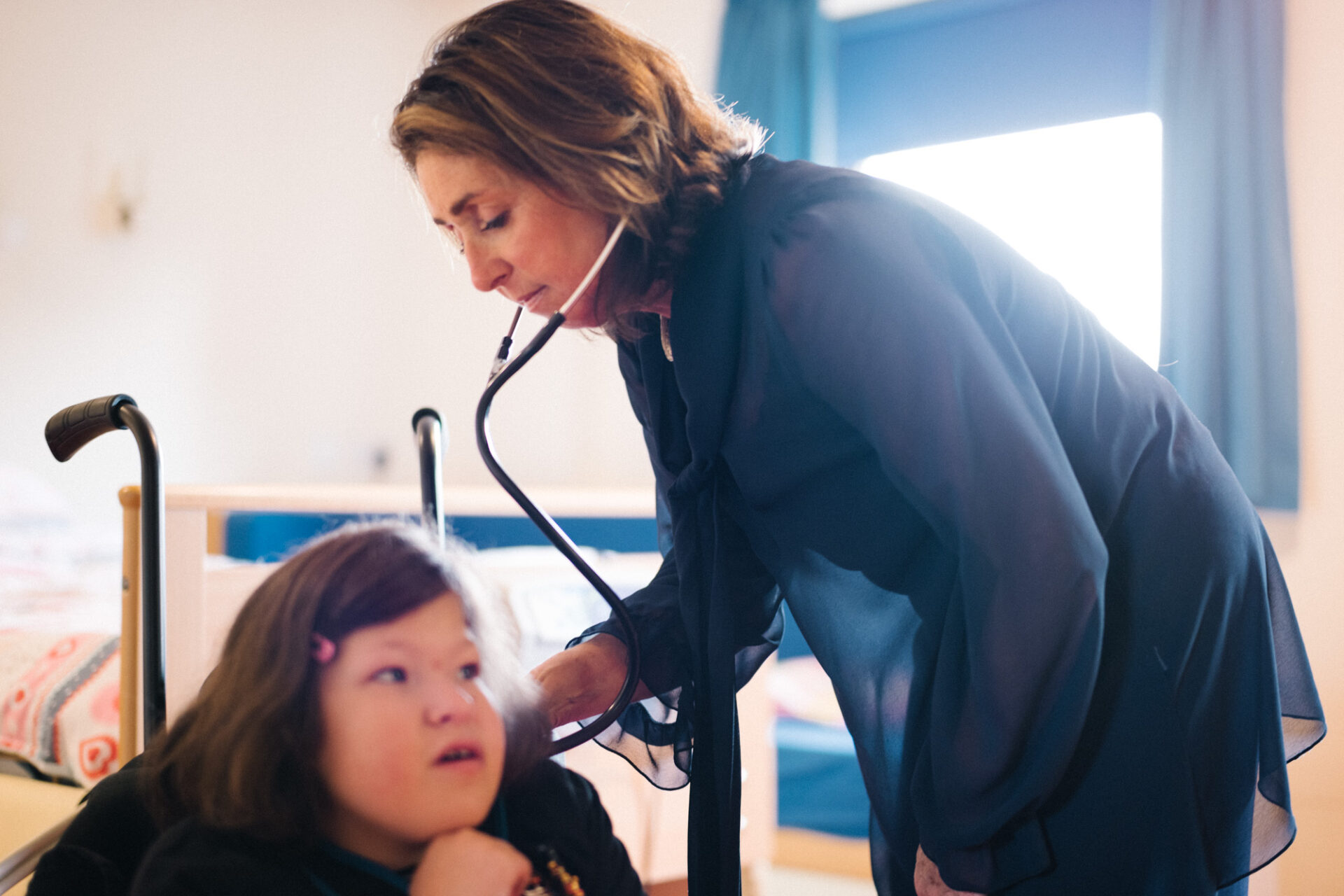 Doctor with stethoscope listening to a child breathing