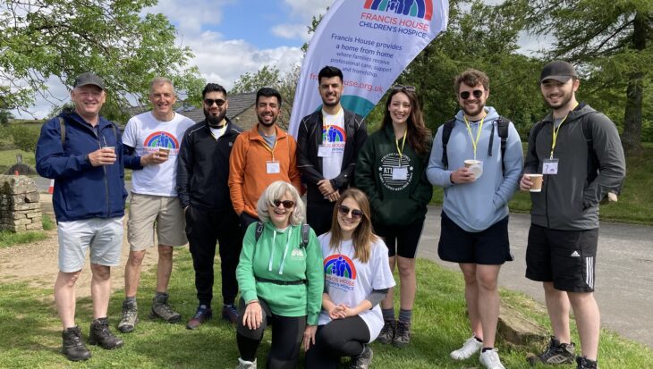 Group of people stood in the countryside wearing Francis House t-shirts