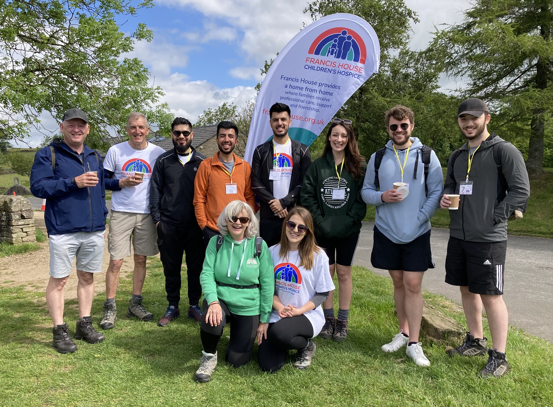 Group of people stood in the countryside wearing Francis House t-shirts