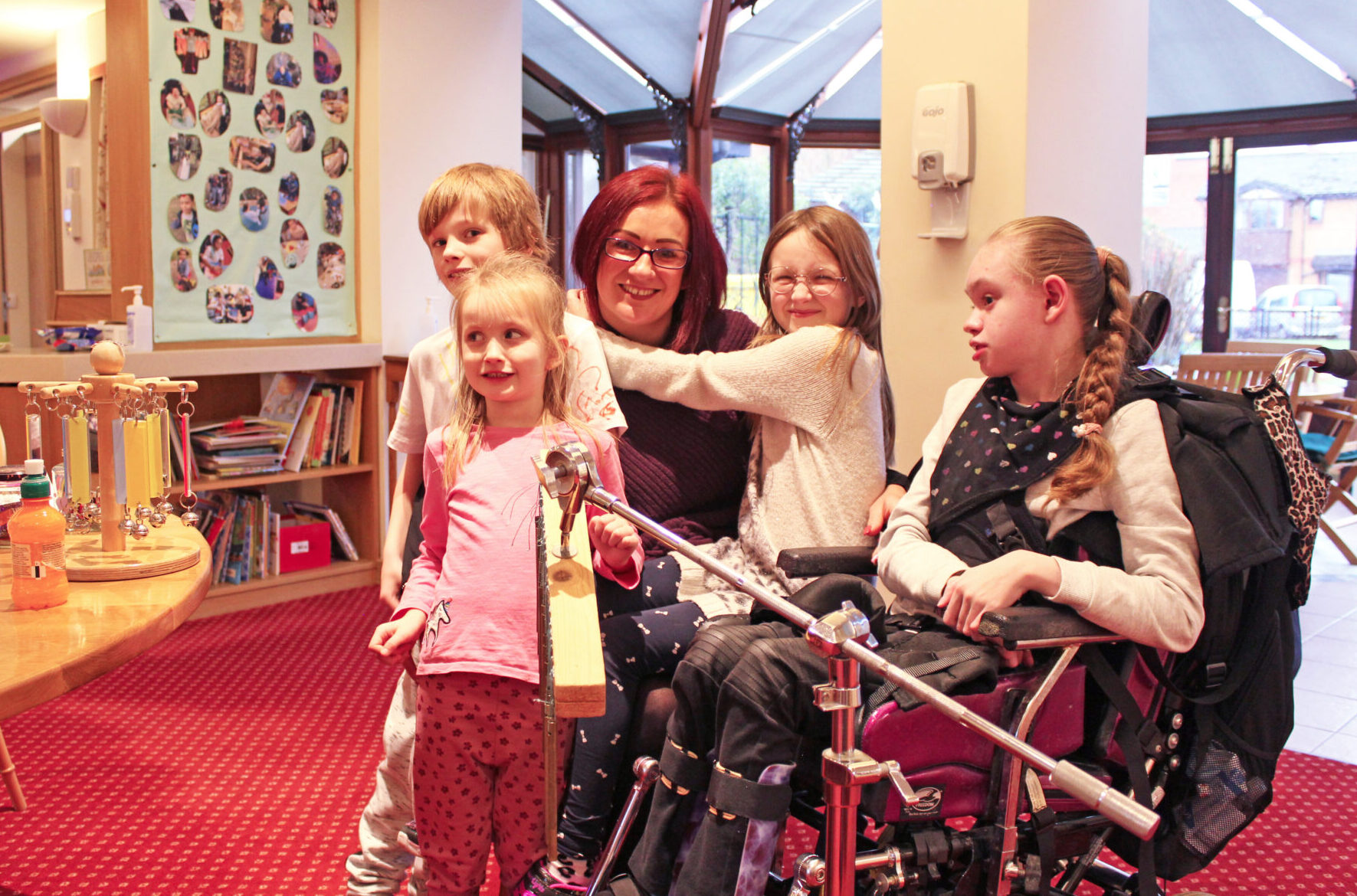 Woman and four young children one child is seated in a wheelchair