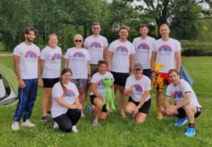 Group of people wearing white Francis House t-shirts stood in a field